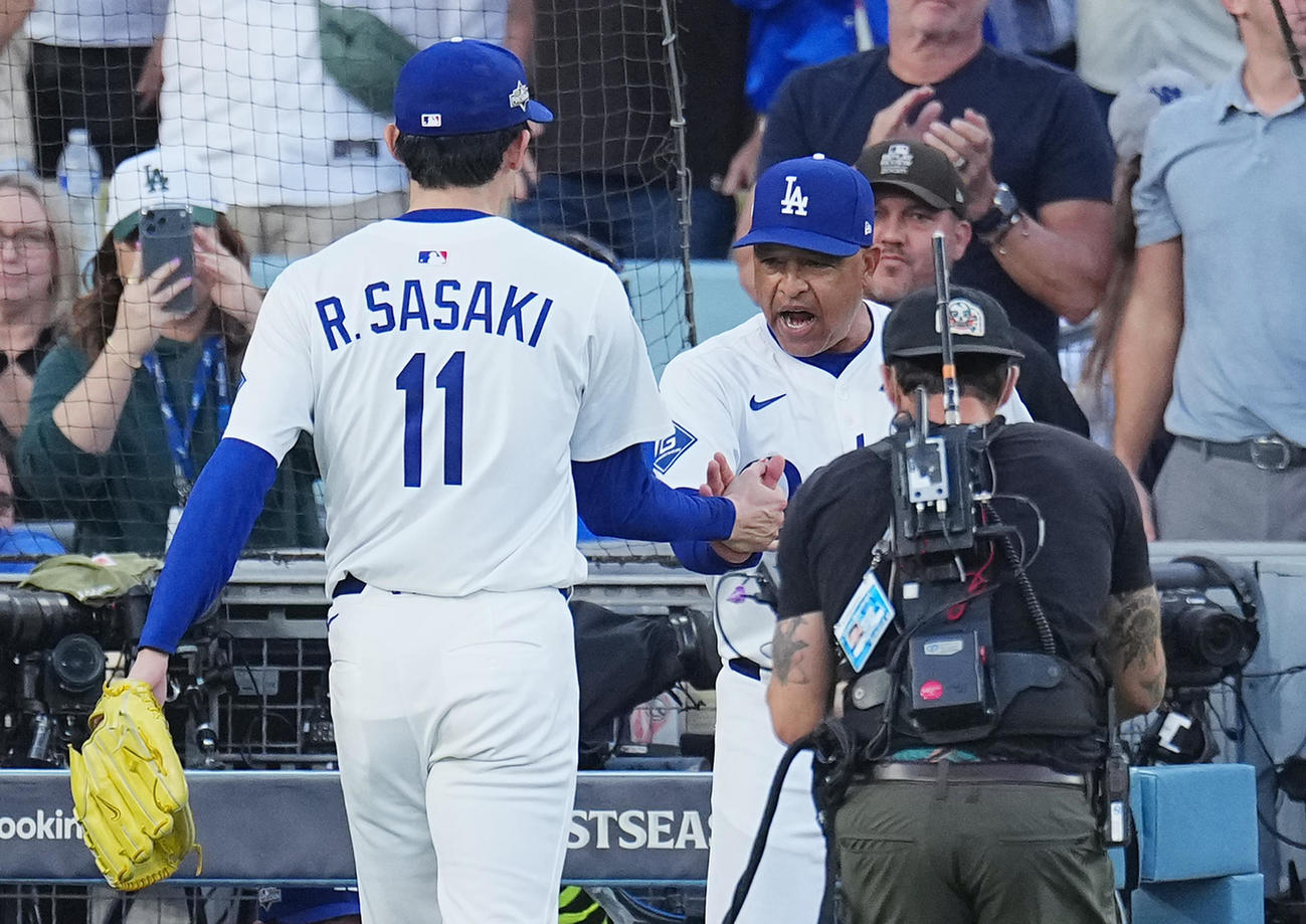 地区シリーズ・ドジャース対フィリーズ　10回の投球を終え、3回を無安打無失点に抑えた佐々木は、ロバーツ監督（右）に迎えられる（撮影・菅敏）