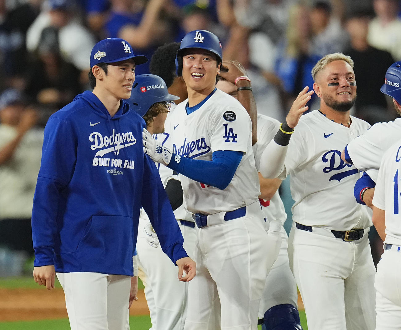 地区シリーズ・ドジャース対フィリーズ　11回、サヨナラでリーグチャンピンシップに進出を決め、佐々木（左）と笑顔を見せる大谷（中央）（撮影・菅敏）