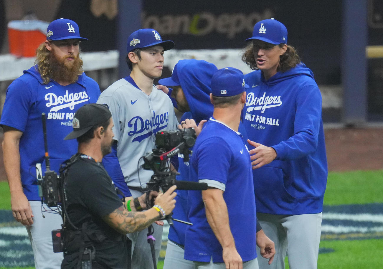 ブルワーズ対ドジャース　初戦を白星で飾り、ナインとタッチをするドジャース佐々木（左から2人目）は、グラスノー（右端）に声をかけられる（撮影・菅敏）