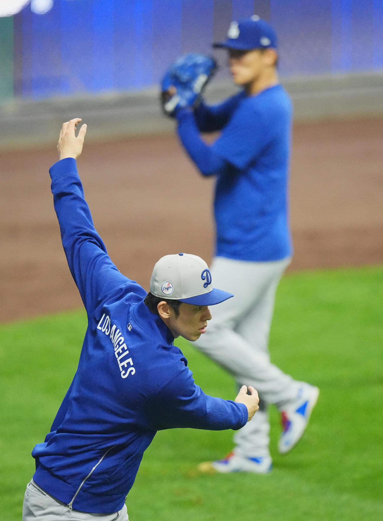 ブルワーズ対ドジャース　試合前、キャッチボールをする山本（後方）を背に調整するドジャース佐々木（撮影・菅敏）