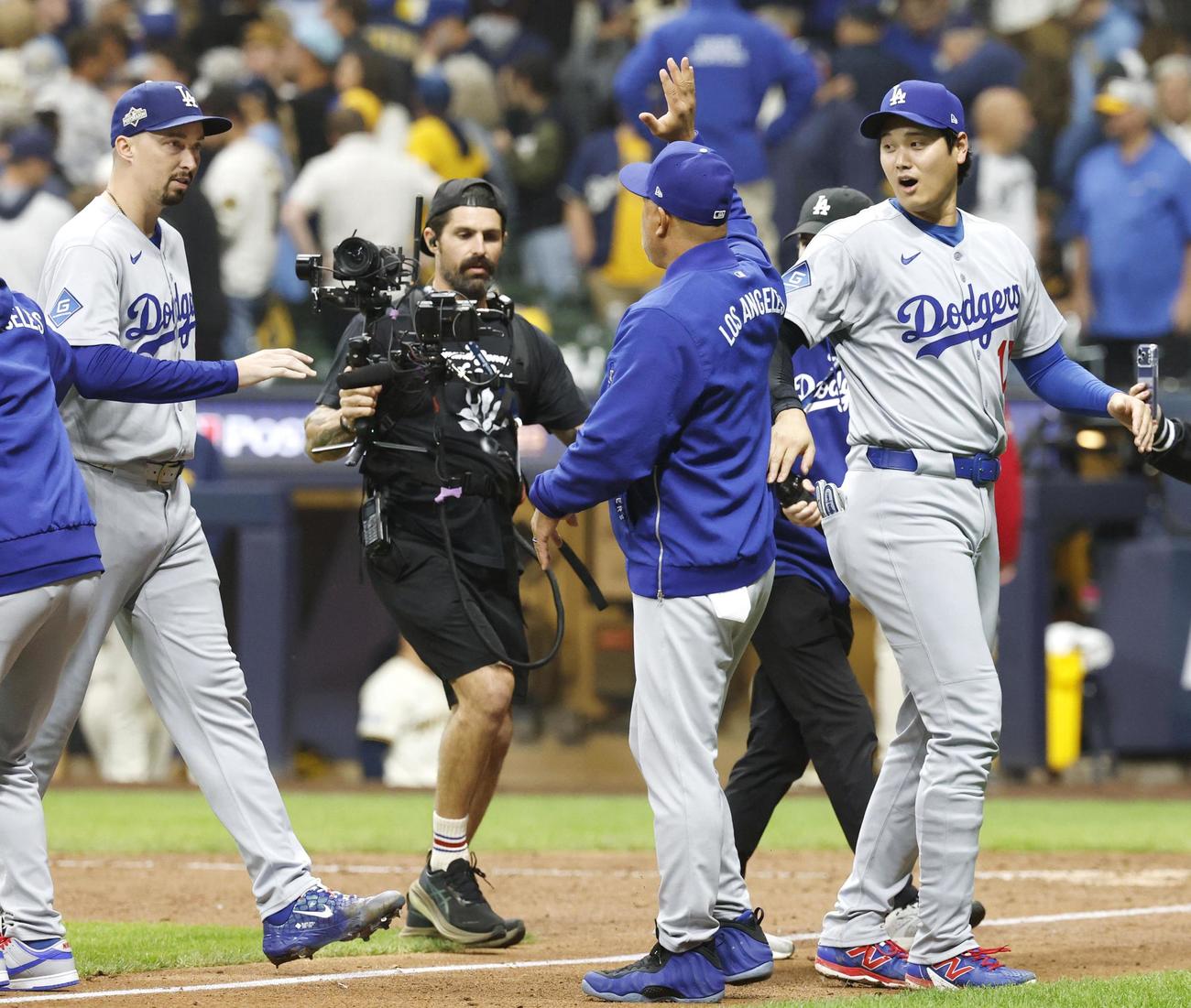 ブルワーズに勝利し、ロバーツ監督とタッチを交わすドジャース大谷（右）（共同）