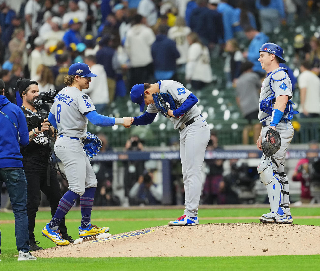 ブルワーズ対ドジャース　完投勝利を飾り、ドジャースK・ヘルナンデス（左）に握手で祝福され、一礼する山本。右はスミス（撮影・菅敏）