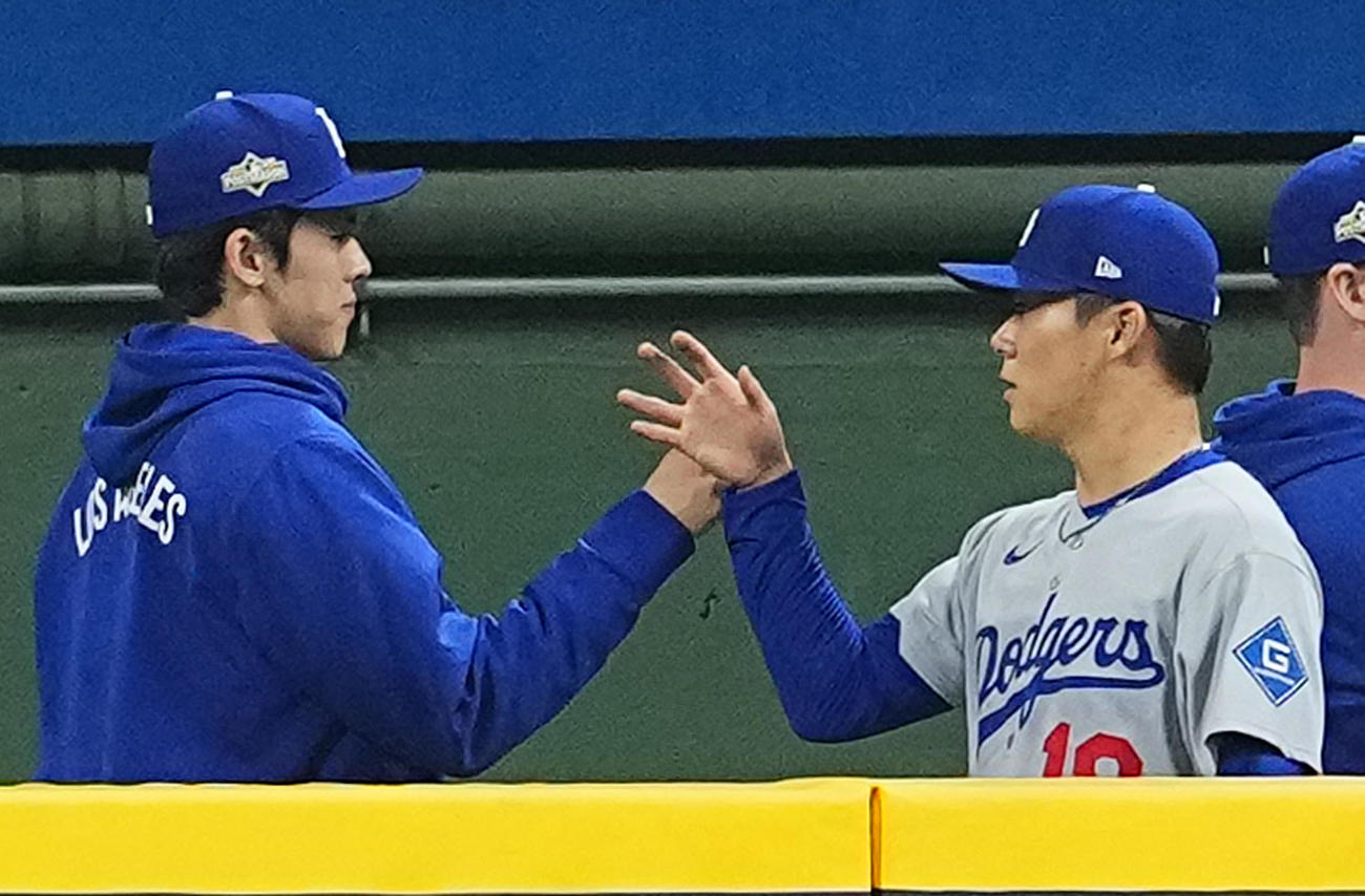 ブルワーズ対ドジャース　ブルペンでのアップを終え、佐々木（左）とタッチをし、試合に臨む山本（撮影・菅敏）