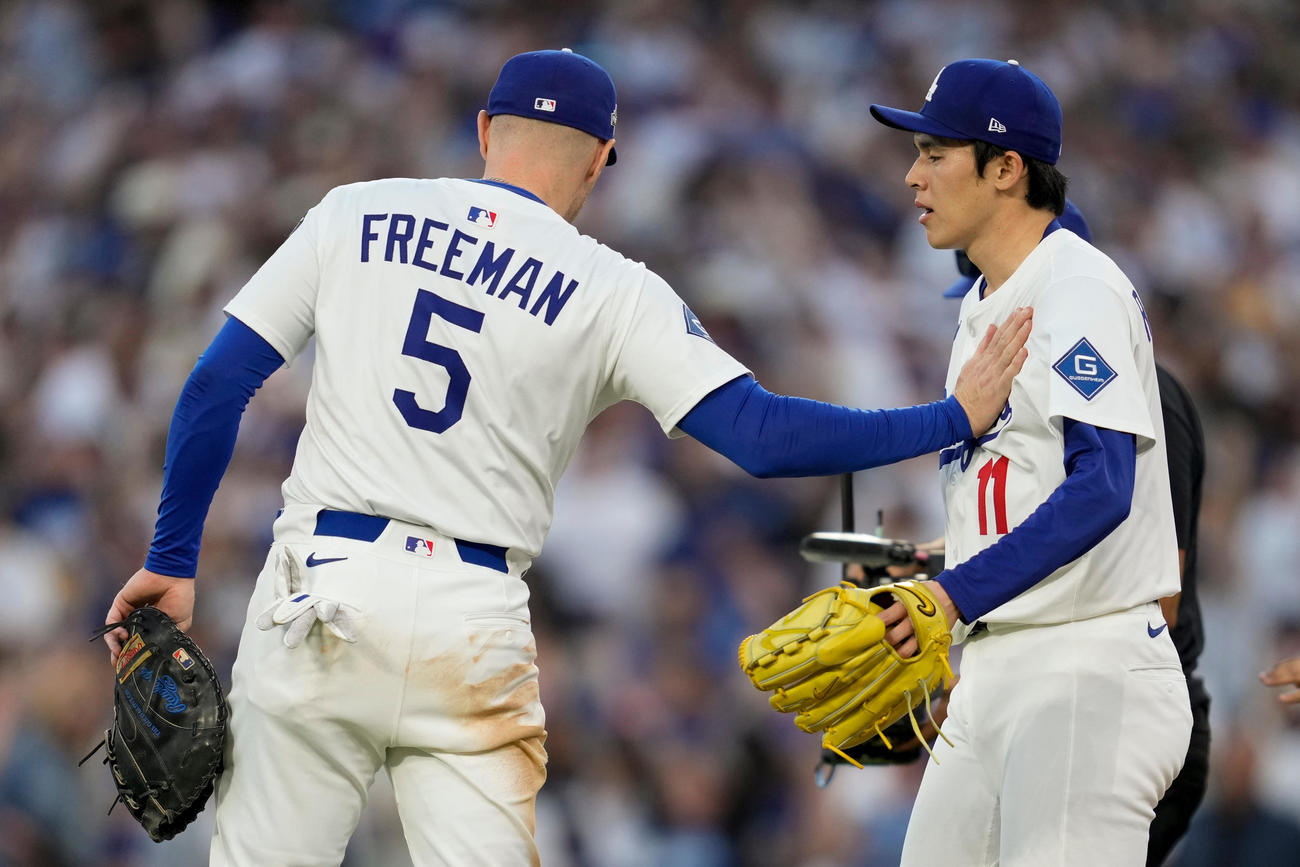 ドジャース佐々木朗希（右）は完璧な投球で試合を締めくくり、同僚のフリーマンから祝福された（AP)