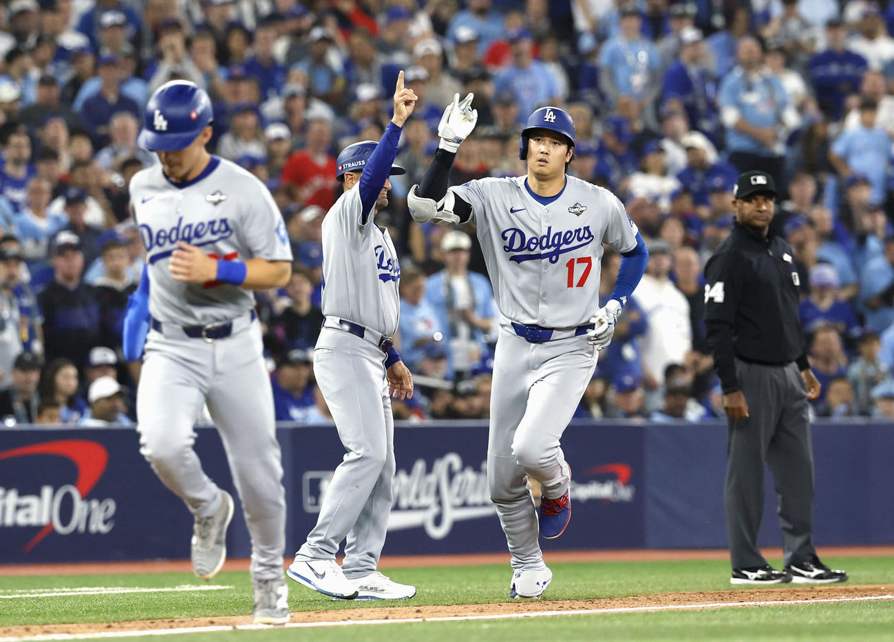 ブルージェイズ戦の7回、2ランを放ち三塁コーチとタッチを交わすドジャース大谷（右）（共同）