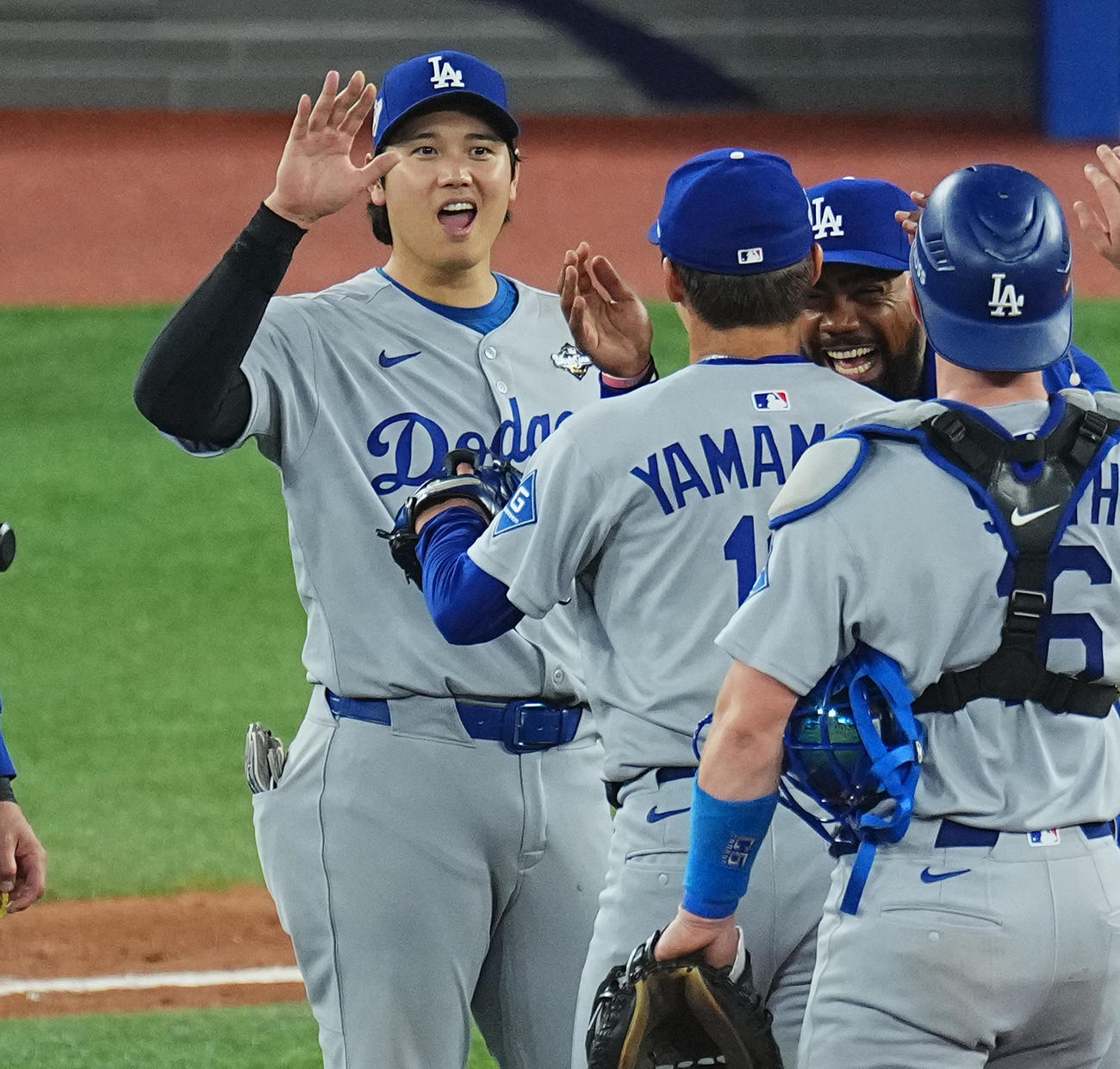 ブルージェイズ対ドジャース　完投勝利を飾った山本（中央）をタッチで迎える大谷（撮影・菅敏）