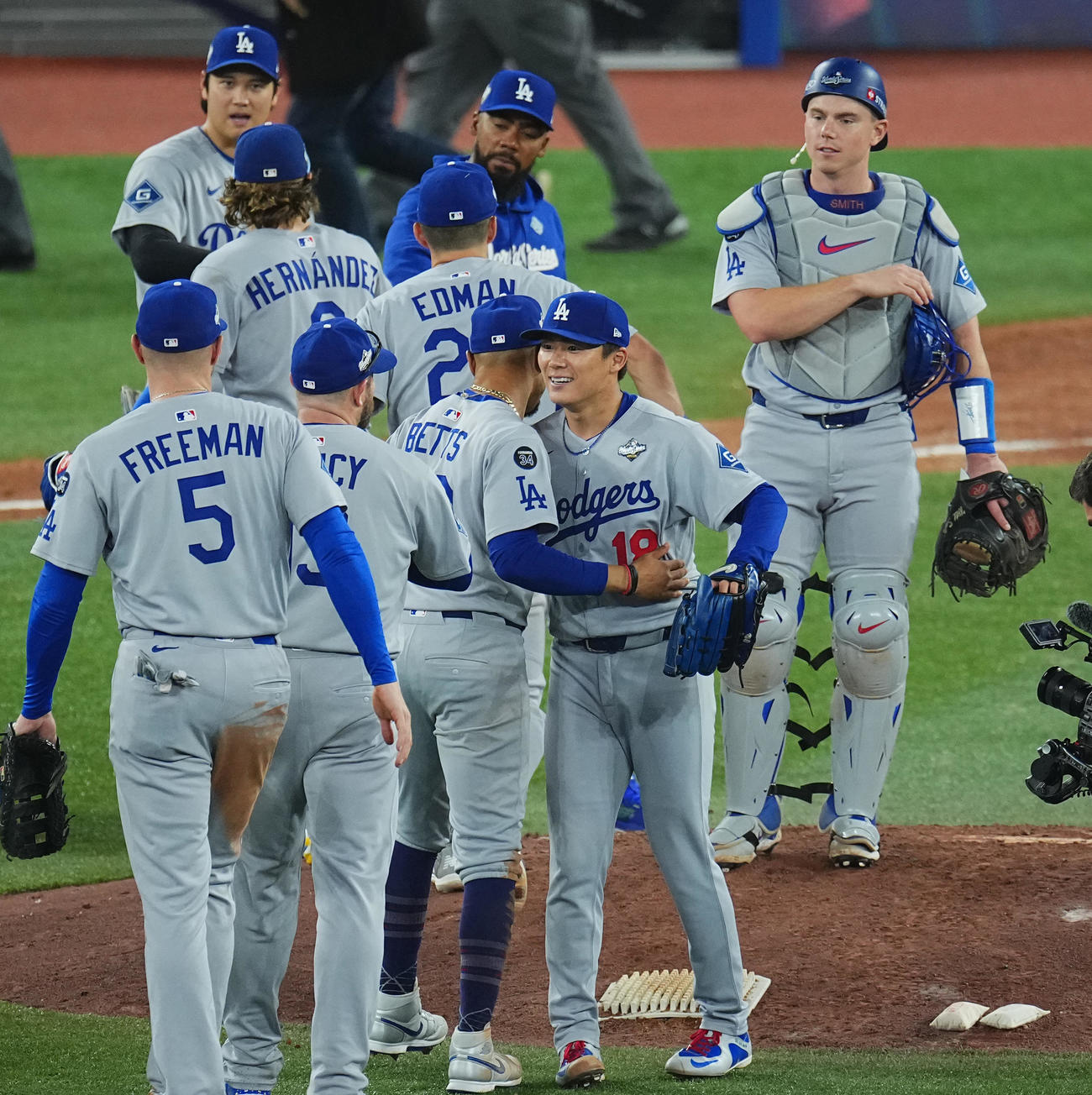 ブルージェイズ対ドジャース　完投勝利を飾り、ベッツ（中央左）らナインに祝福される山本（撮影・菅敏）