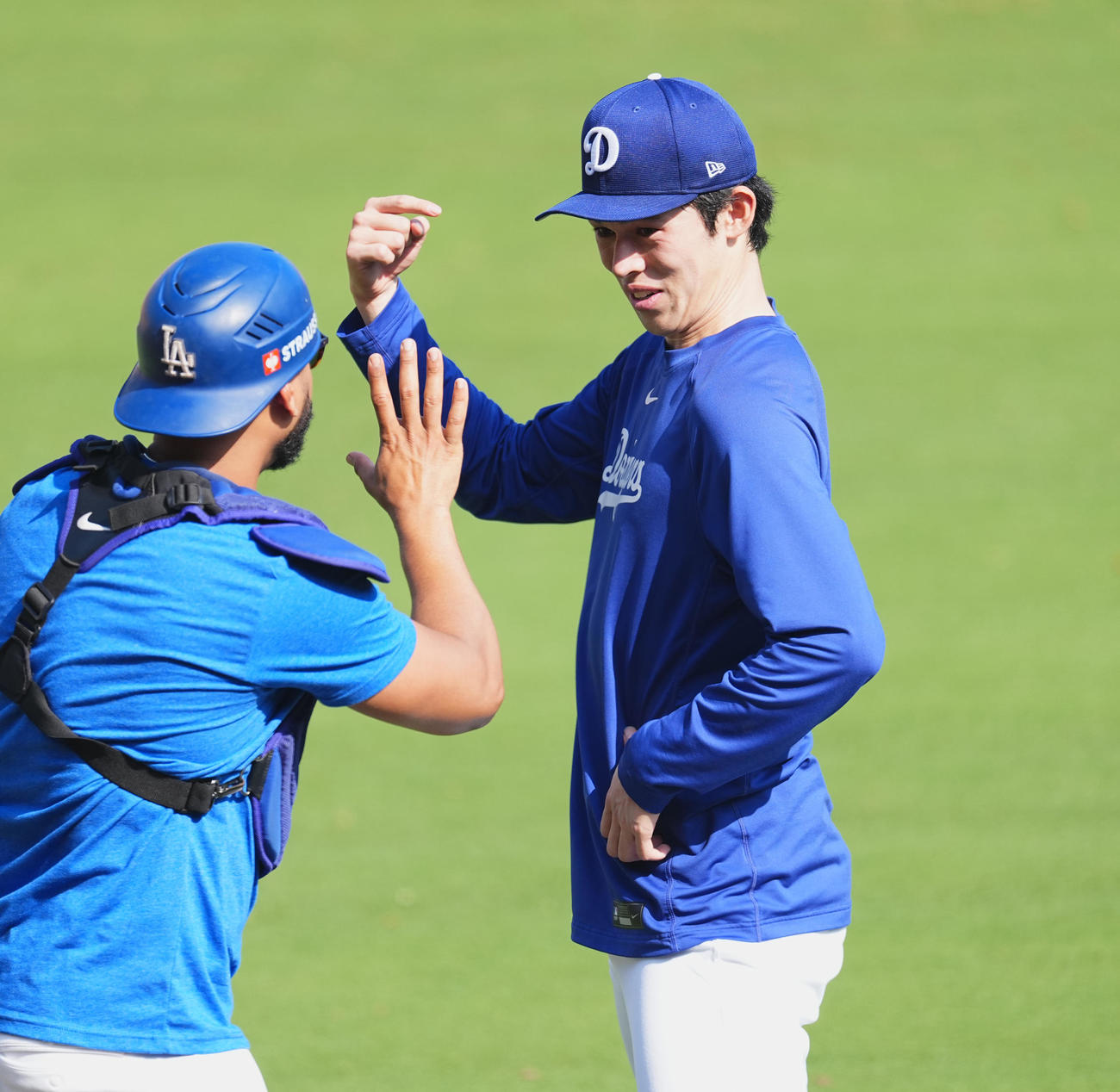ワールドシリーズ第3戦、試合前の練習中に同僚と笑顔で話すドジャース佐々木（右）（撮影・菅敏）