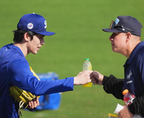 ワールドシリーズ第3戦、試合前の練習中に球場係員とタッチをするドジャース佐々木（撮影・菅敏）