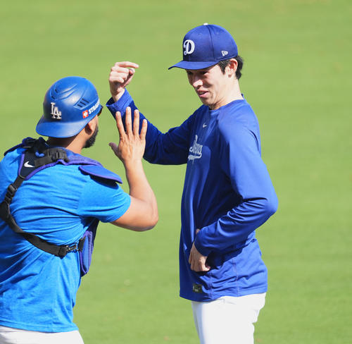 ワールドシリーズ第3戦、試合前の練習中に同僚と笑顔で話すドジャース佐々木（右）（撮影・菅敏）