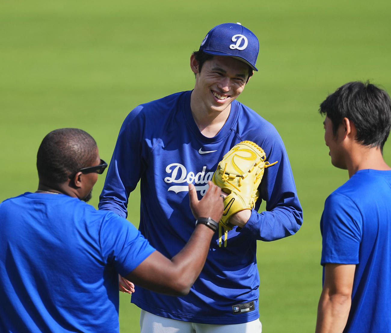 ワールドシリーズ第3戦、試合前の練習中にスタッフと笑顔で話すドジャース佐々木（中央）（撮影・菅敏）