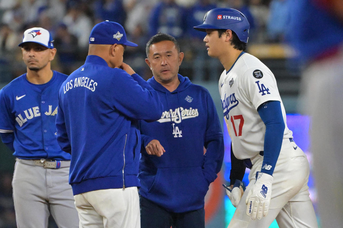ドジャース大谷翔平（右）は二塁進塁時に足に異変を感じたようなしぐさを見せ、ロバーツ監督らが駆け寄った（ロイター）