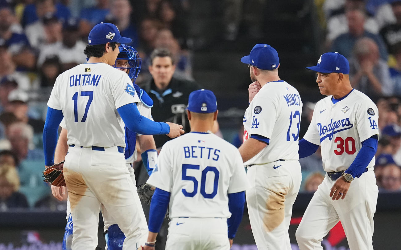 ドジャース対ブルージェイズ　7回表ブルージェイズ無死二、三塁、ロバーツ監督（右）にボールを手渡し降板する大谷（撮影・菅敏）