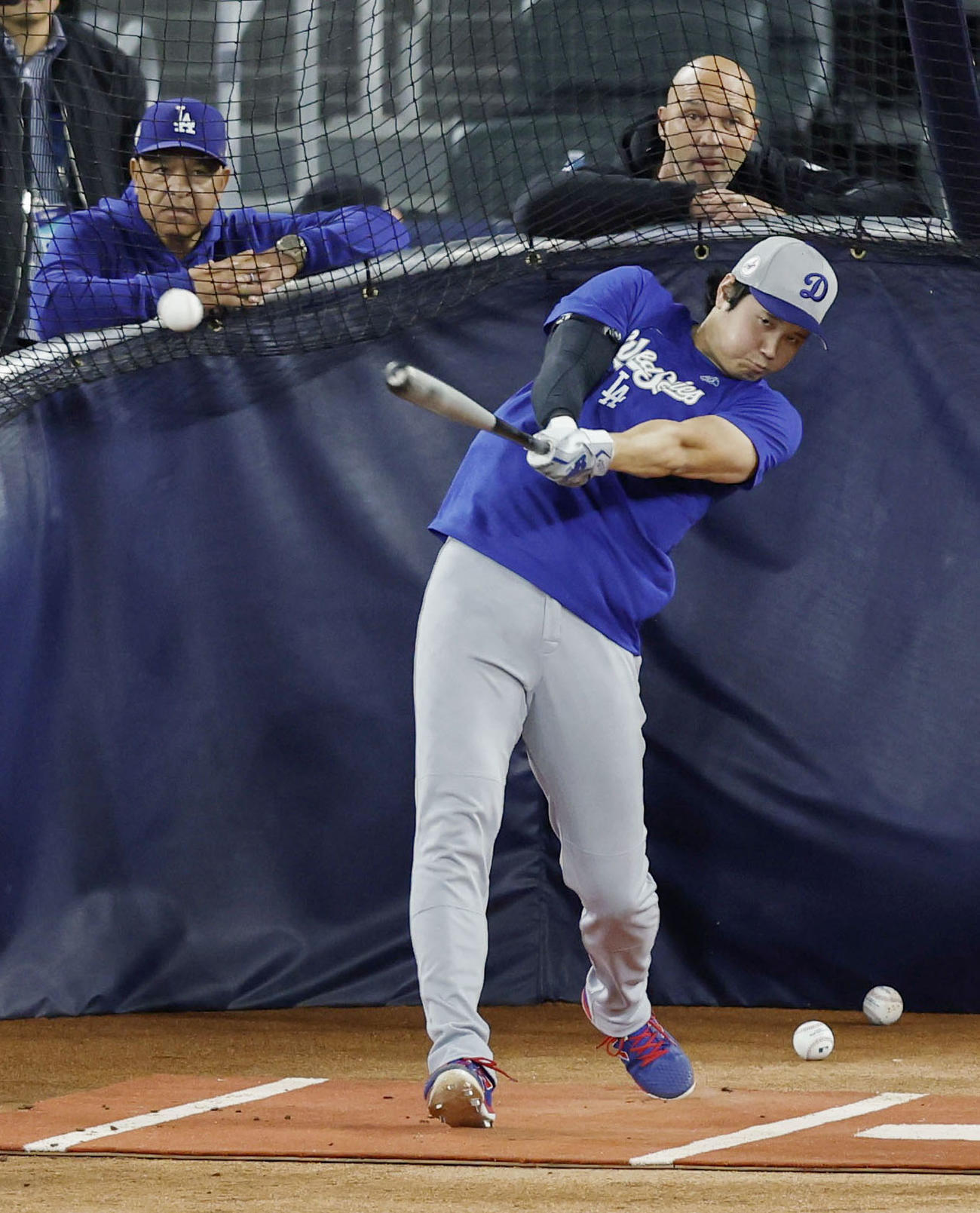 グラウンドで打撃練習するドジャース大谷。左はロバーツ監督（共同）