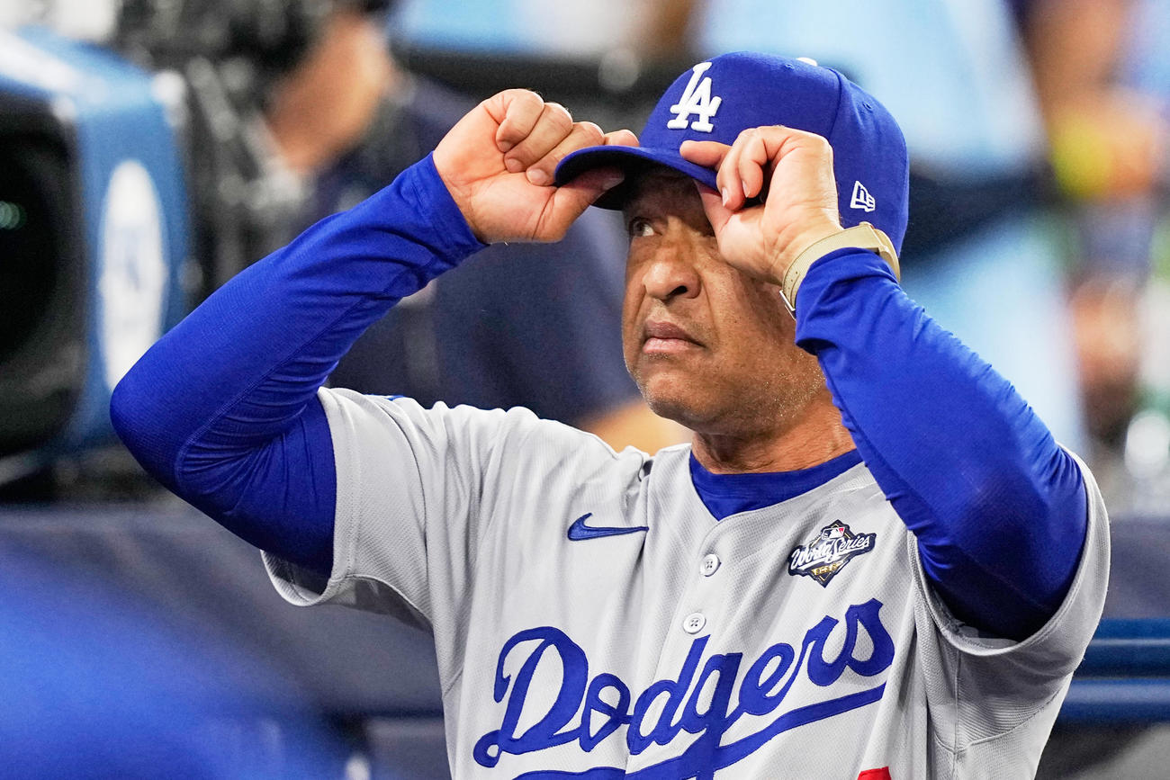 試合前に選手の練習を見つめるドジャース・ロバーツ監督（AP)