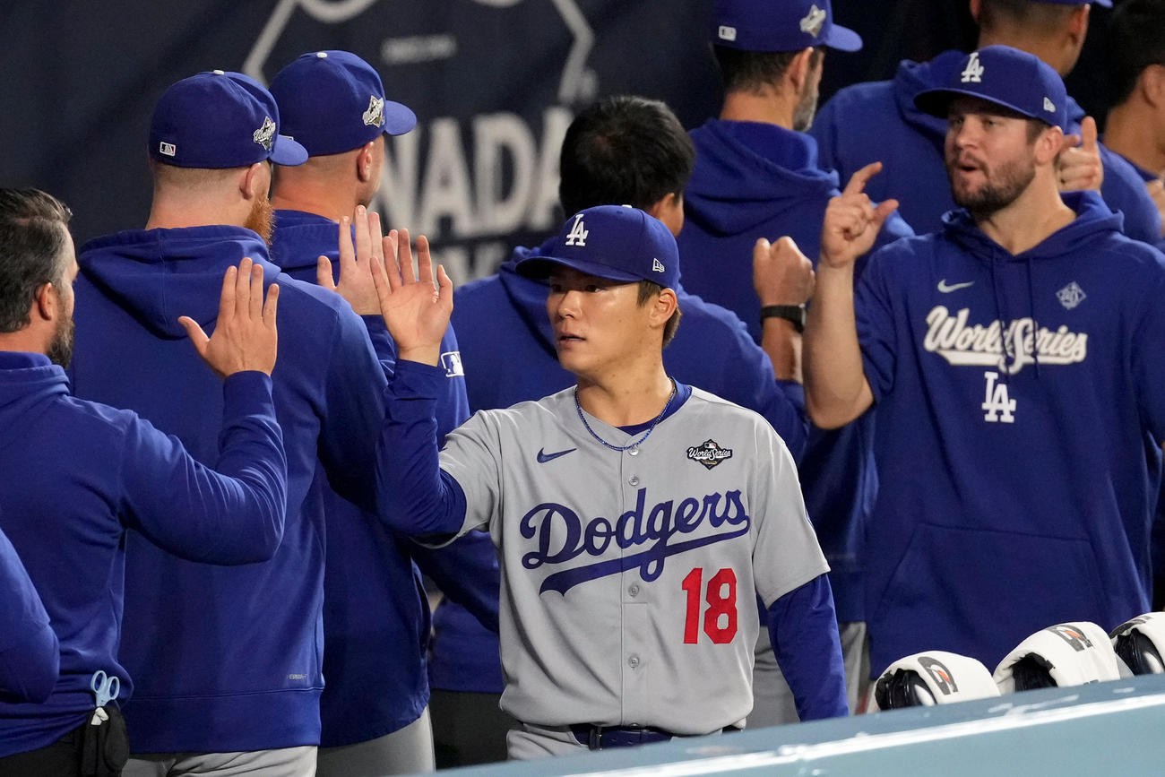 試合前に同僚とハイタッチする山本由伸（AP)