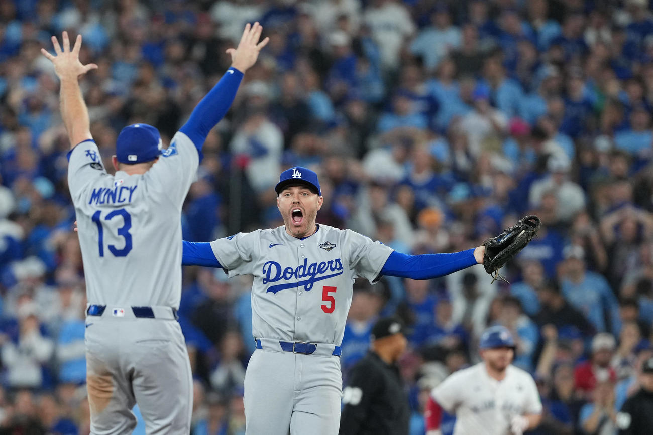 ワールドシリーズ連覇のアウトを取ったドジャース一塁手のフリーマン（中央）は、驚きの表情でマンシーに駆け寄る（ロイター）