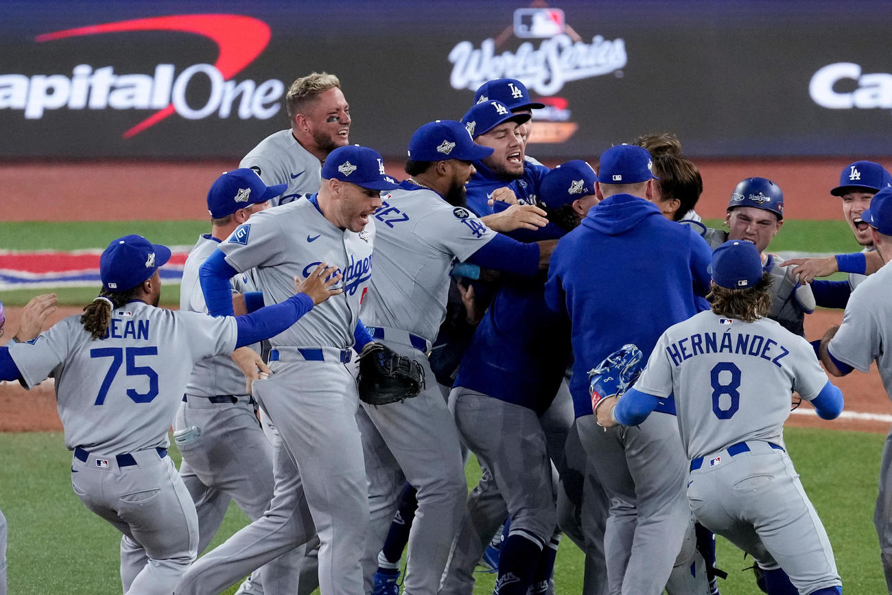 ワールドシリーズ連覇を果たし、マウンドで歓喜の輪ができる中、最後のアウトを取ったドジャース一塁手のフリーマンは輪に入る直前、お尻のポケットにウイニングボールをしまう（AP）