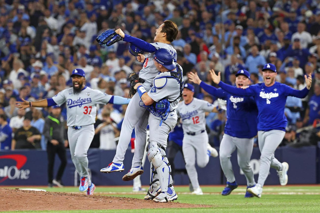 米大リーグ、ブルージェイズとのワールドシリーズ第7戦を制して2連覇を達成し、捕手スミスに抱きかかえられるドジャースの山本由伸＝2日、トロント（ゲッティ＝共同）