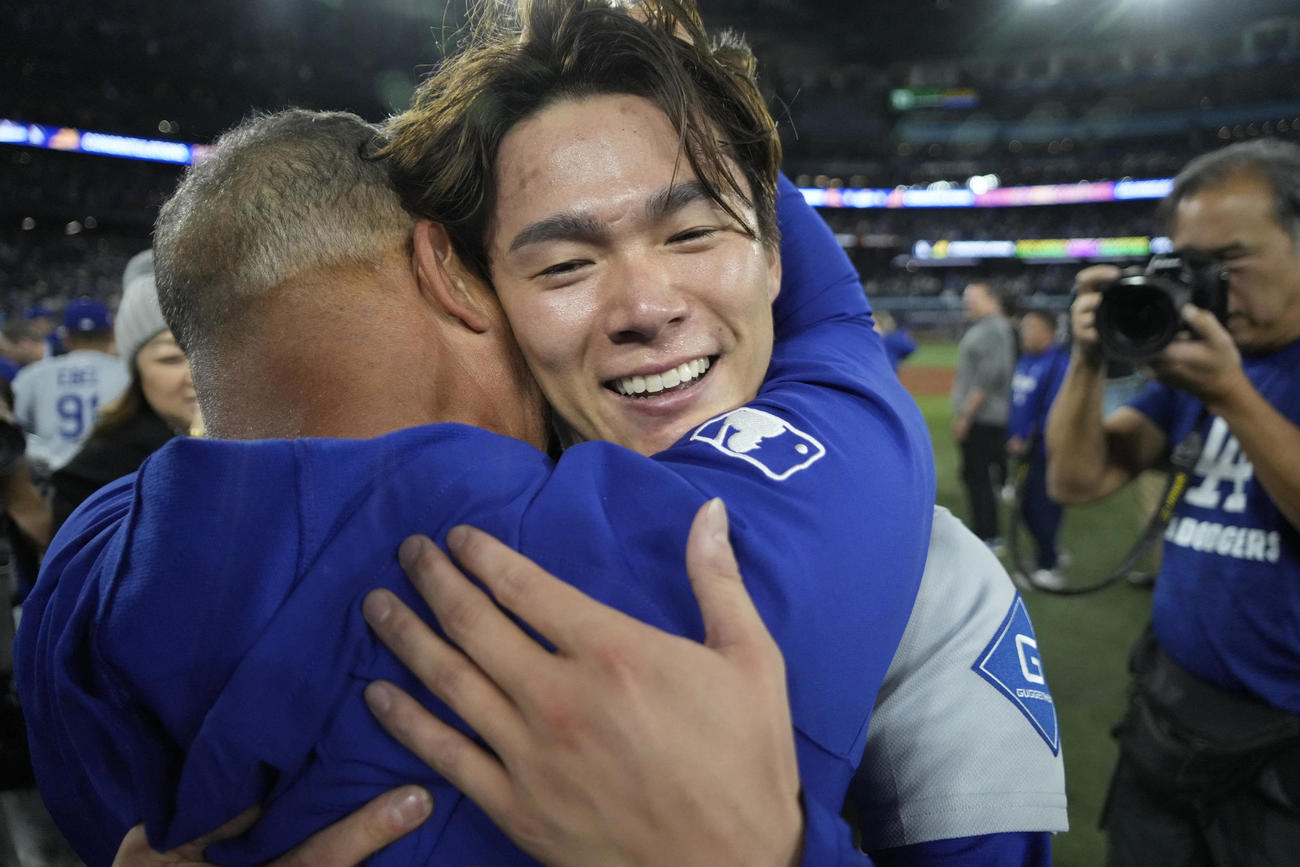 ワールドシリーズMVPに輝いた山本由伸は、ロバーツ監督に抱きしめられる（ロイター）