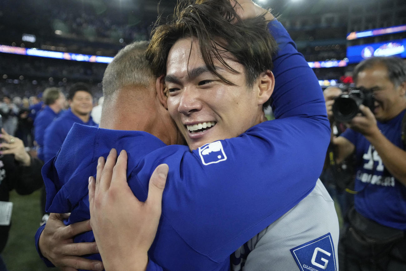 ワールドシリーズMVPに輝いた山本由伸は、ロバーツ監督に抱きしめられる（ロイター）