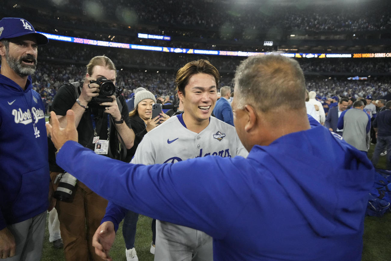 ワールドシリーズMVPに輝いた山本由伸は、ロバーツ監督に祝福を受ける（ロイター）