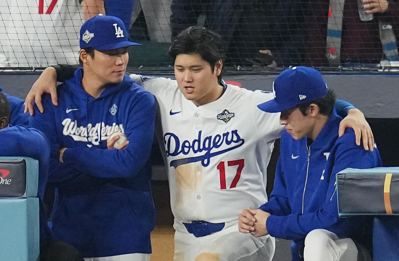10月27日、ワールドシリーズ第3戦、ドジャース対ブルージェイズ　12回、ベンチで試合を見守る山本（左）と佐々木（右）の間に入り、肩を組んで話す大谷（撮影・菅敏）