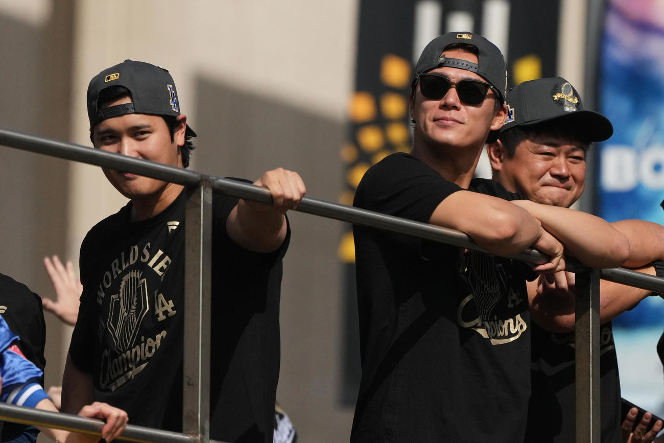 優勝パレードで笑顔を見せた大谷翔平（左）と大観衆を見つめる山本由伸（AP)