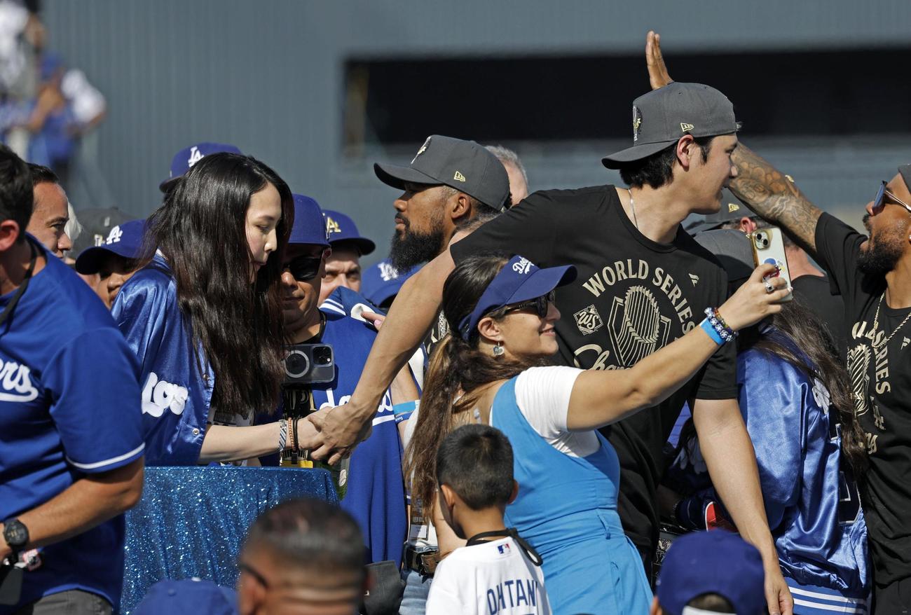 米大リーグ、ドジャースのワールドシリーズ優勝報告会を終え、妻真美子さんの手をとり、引き揚げる大谷翔平（共同）