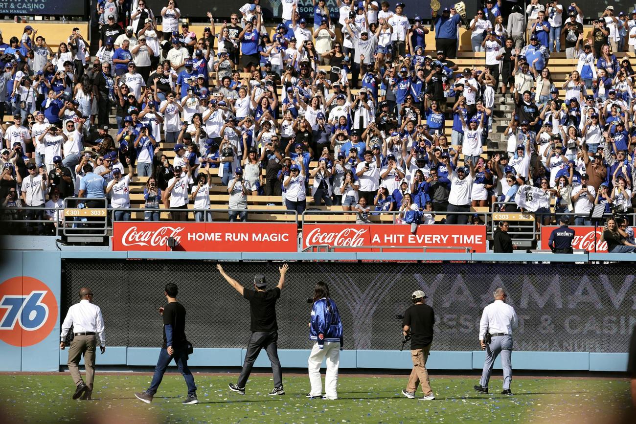 米大リーグ、ドジャースのワールドシリーズ優勝報告会を終え、ファンの歓声に応えながら引き揚げる大谷翔平と妻の真美子さん（中央の2人）（共同）