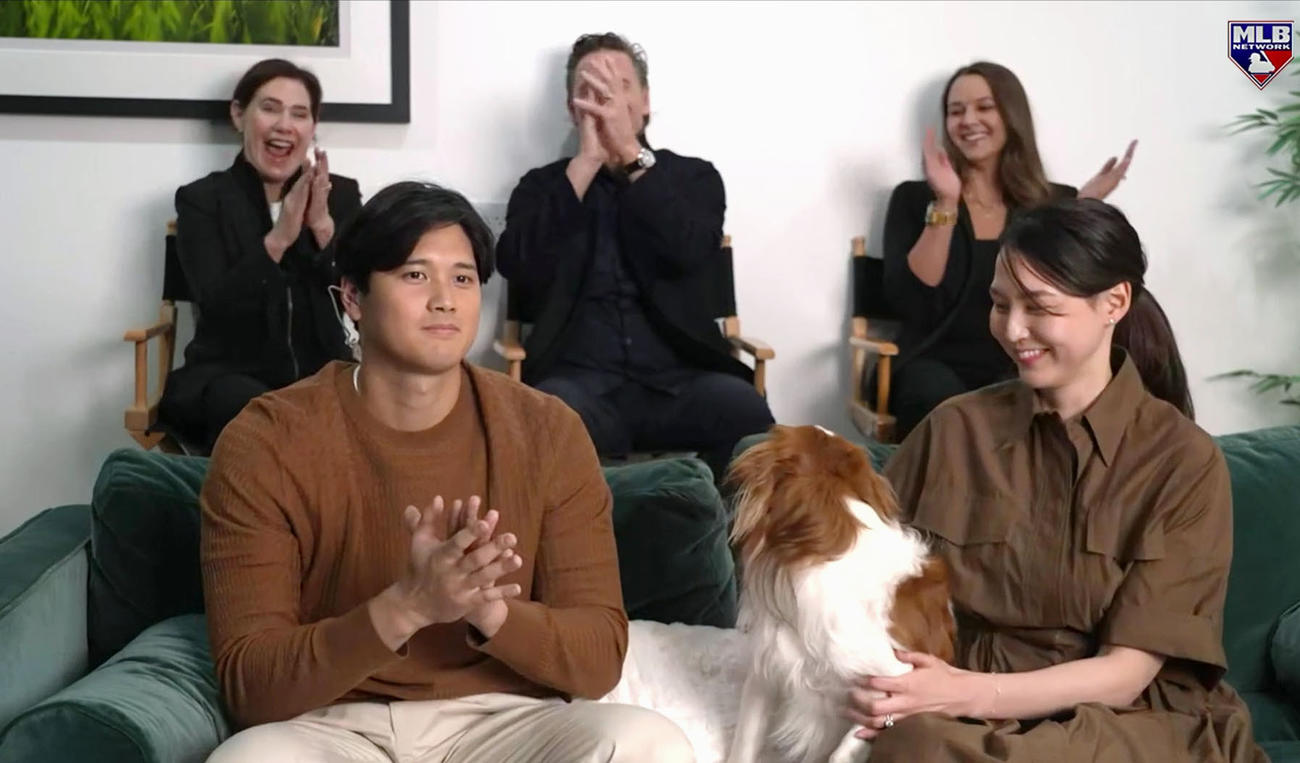 米大リーグ、ナショナル・リーグのMVPに満票で選ばれ、MLBネットワークの番組で喜ぶドジャースの大谷翔平。右は妻真美子さん（共同）