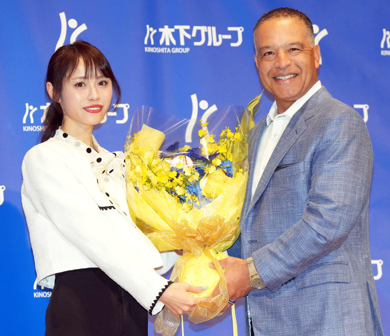 木下グループの新CM発表会見に登壇し花束を贈られるドジャースのロバーツ監督（撮影・たえ見朱実）