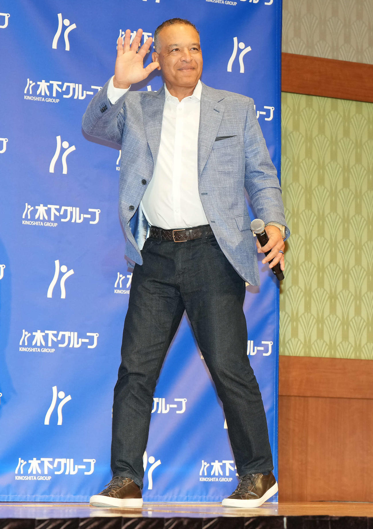 木下グループの新CM発表会見に登壇し、笑顔で手を振るドジャースのロバーツ監督（撮影・たえ見朱実）