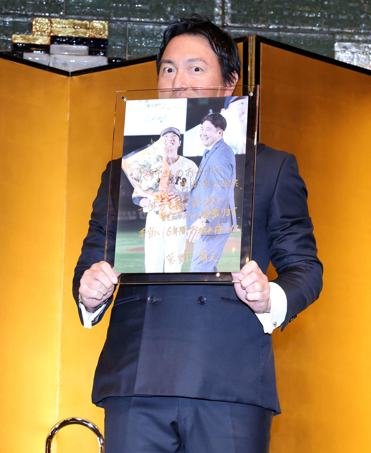 スペシャルトークショーで菅野からサイン入りの2人の写真を贈られ笑顔の長野久義氏（撮影・浅見桂子）