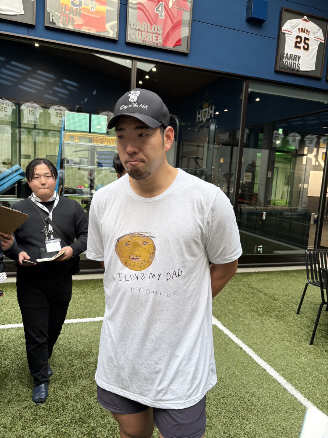 長男レオ君が描いたパパの似顔絵Tシャツで取材を受けるエンゼルス菊池（撮影・久保賢吾）