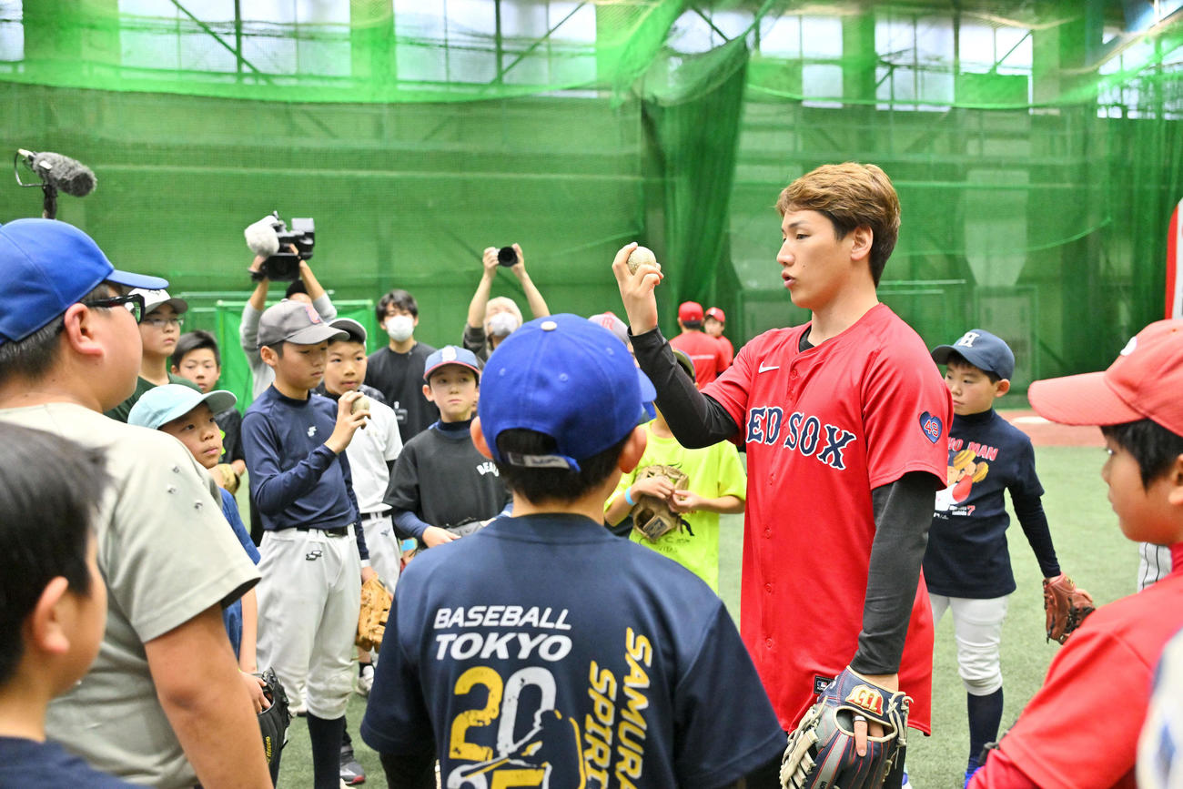 子どもたちにボールの握りを教えるレッドソックス吉田（撮影・滝沢徹郎）