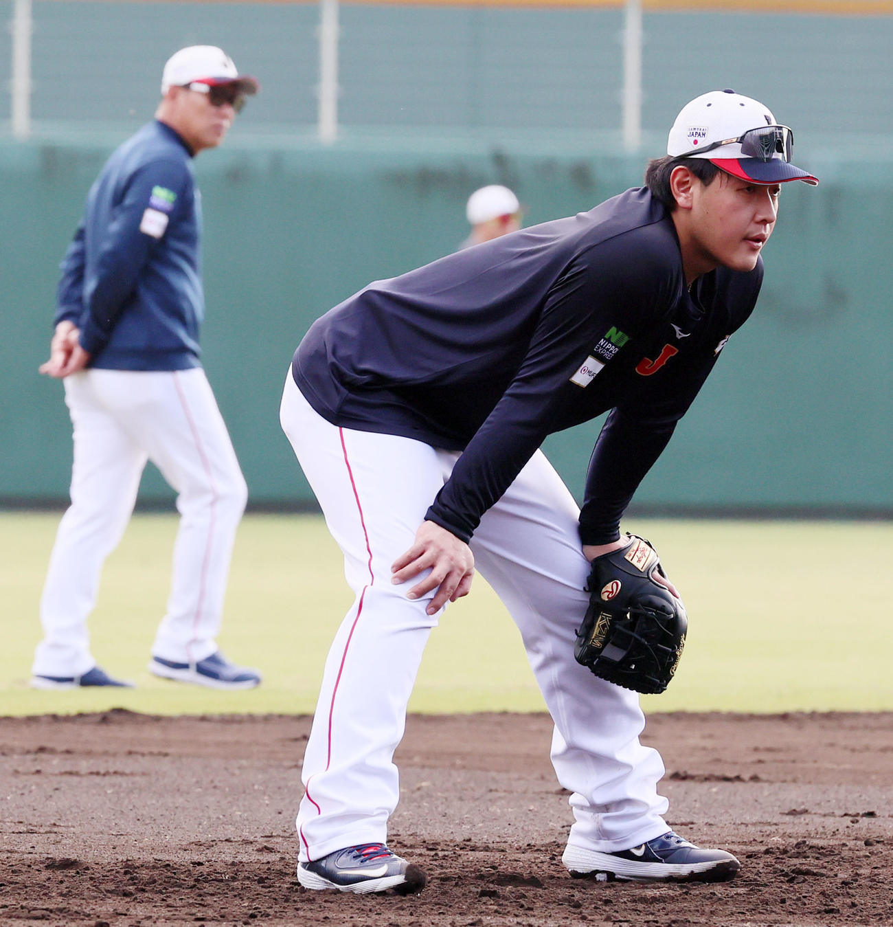 侍ジャパン宮崎合宿　三塁で守備に就く岡本和真。左は井端弘和監督（25年11月撮影）