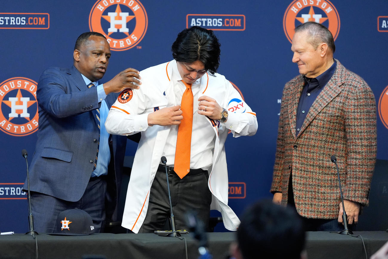 アストロズ入団会見でユニホームを着る今井達也。左はアストロズのゼネラルマネジャーのダナ・ブラウン氏、右は代理人のスコット・ボラス氏（AP）