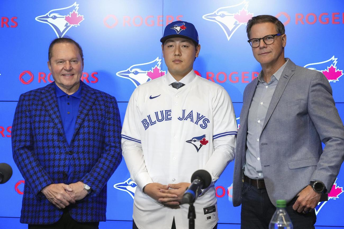 米大リーグ、ブルージェイズの入団記者会見で記念写真に納まる岡本和真内野手（中央）（左は代理人のスコット・ボラス氏、右はロス・アトキンスGM）（共同）