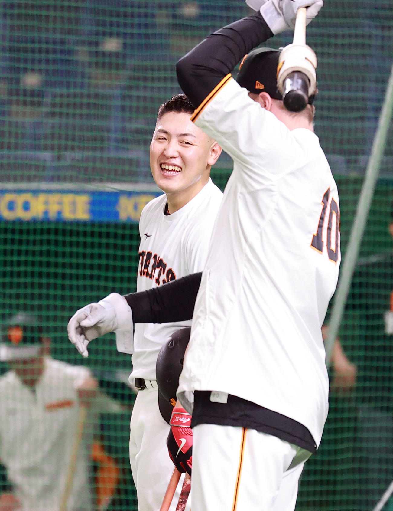 頭髪をすっきりさせた岡本和真は、スモークと談笑する（2021年6月撮影）