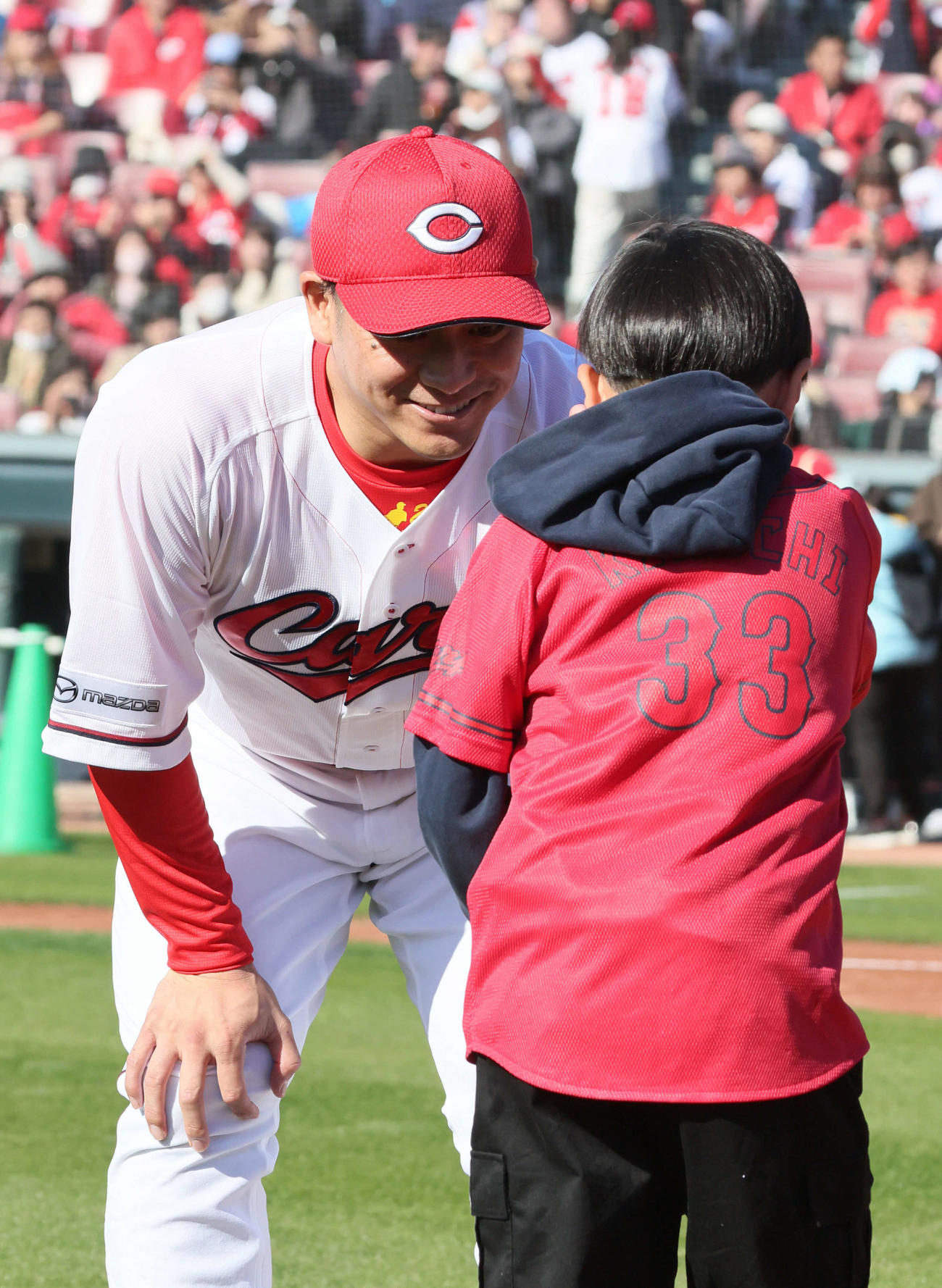 ファンとグラウンドでハイタッチする田中広輔（2025年11月撮影）　
