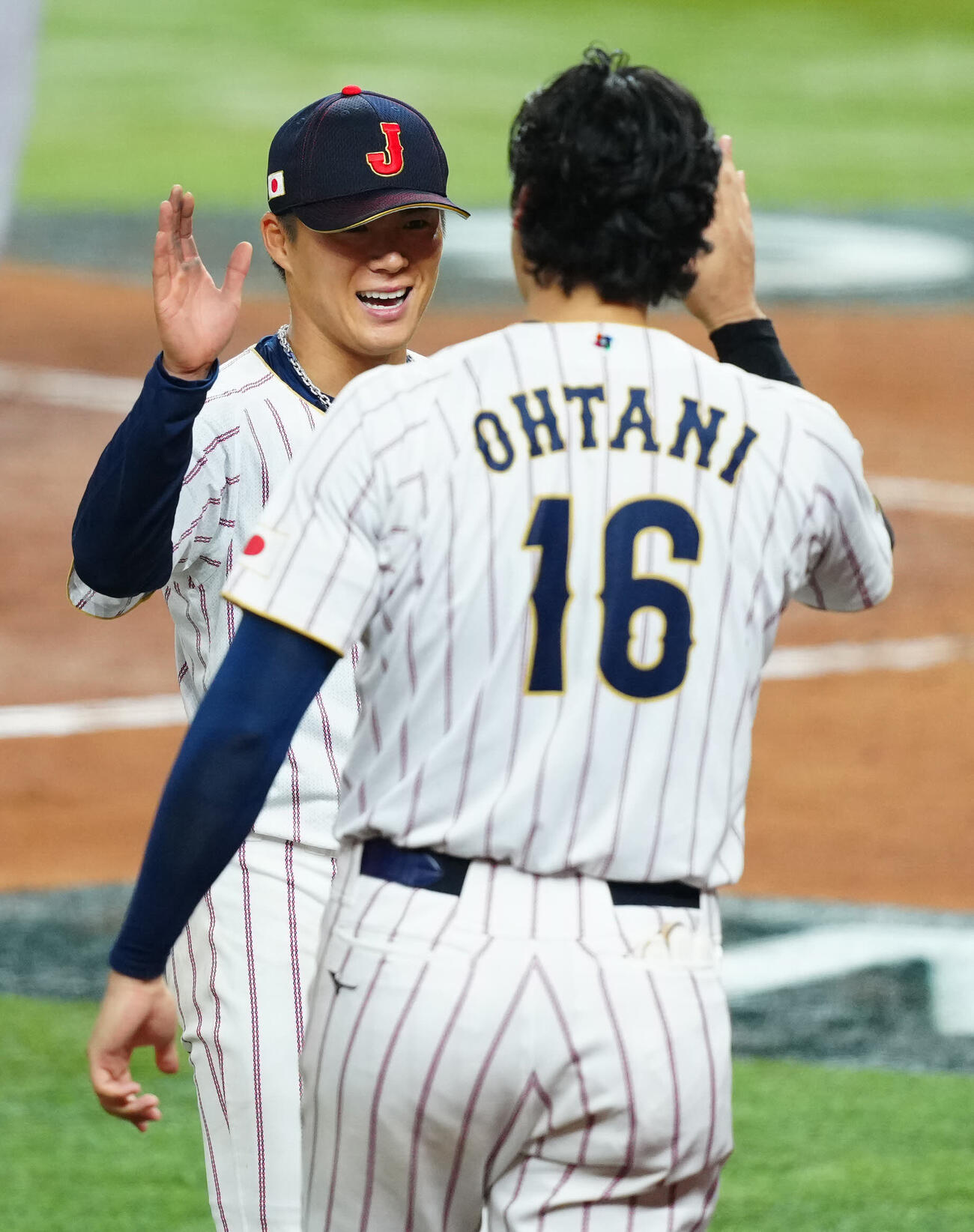 日本対ベネズエラ　4回裏ベネズエラの攻撃を無失点に抑えた山本（中央）は大谷と笑顔でタッチを交わす（撮影・垰建太）
