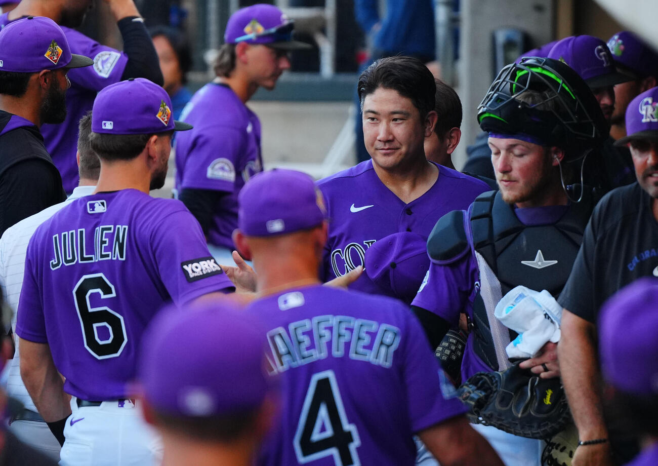 ロッキーズ対ジャイアンツ　試合に向けナインと笑顔でタッチを交わすロッキーズ先発の菅野（中央）（撮影・垰建太）