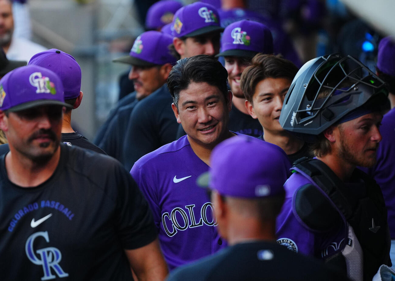 ロッキーズ対ジャイアンツ　試合に向けナインと笑顔でタッチを交わすロッキーズ先発の菅野（中央）（撮影・垰建太）