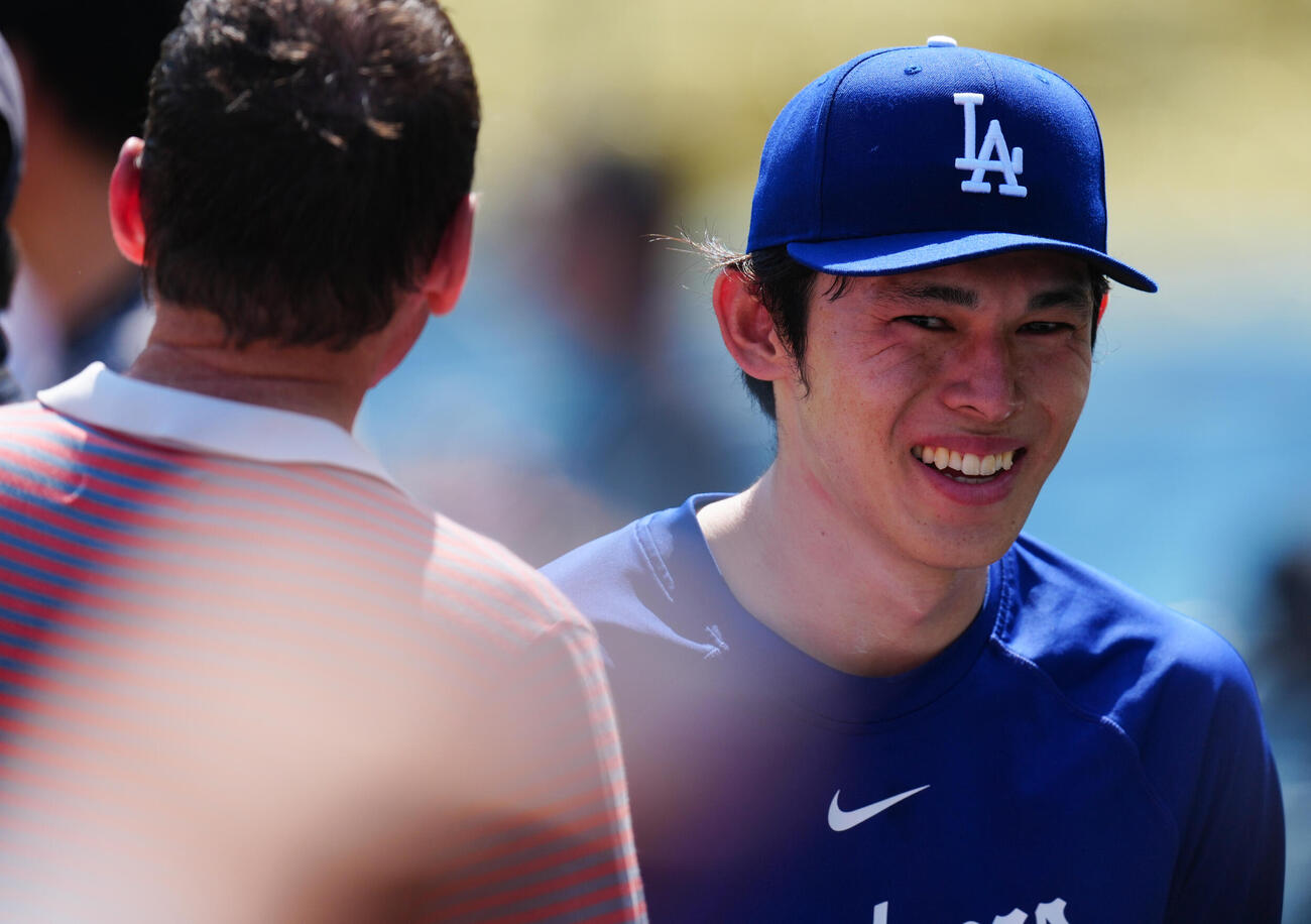 ドジャース対エンゼルス　試合前、関係者と談笑するドジャース佐々木（右）（撮影・垰建太）