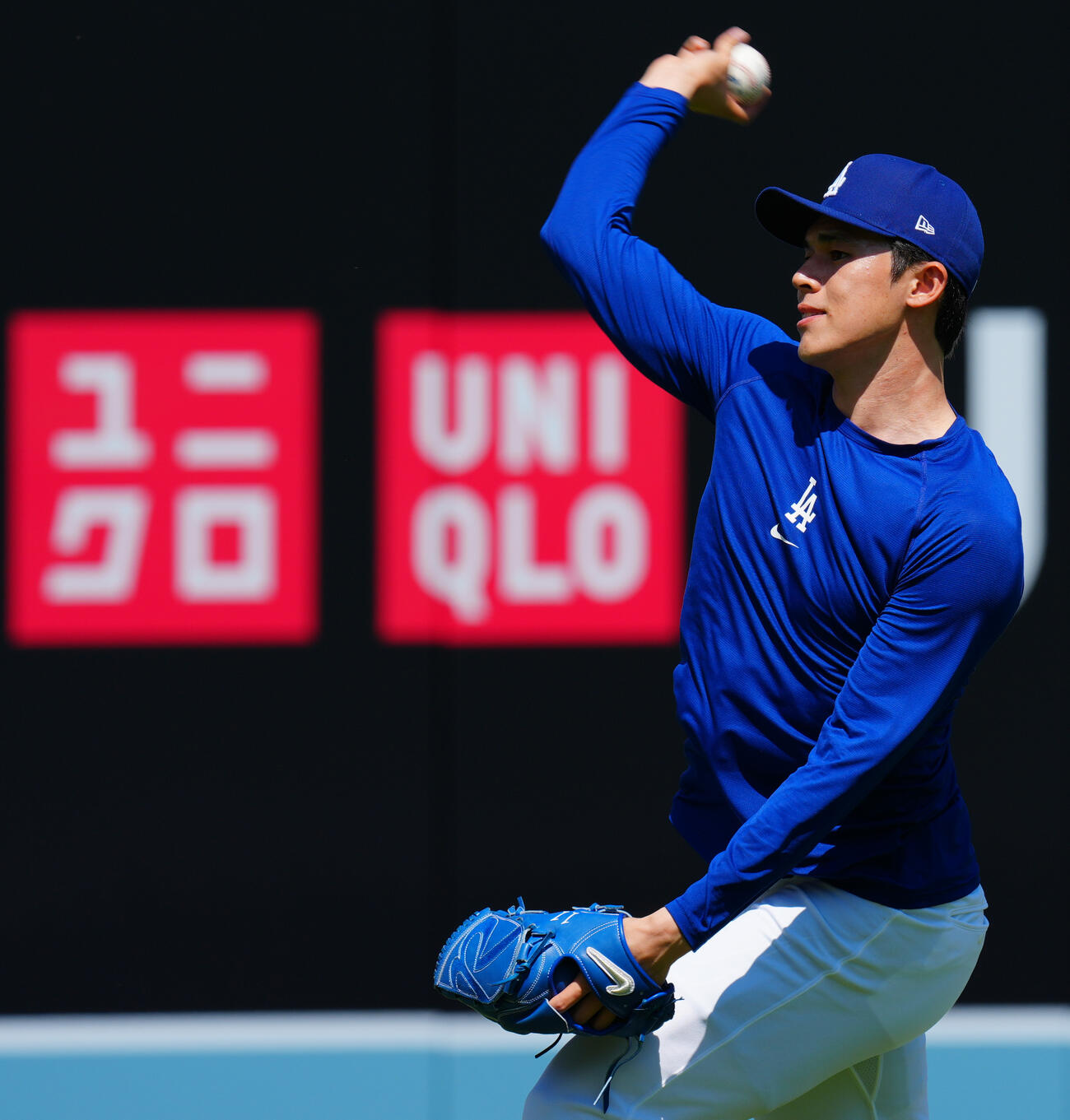 ドジャース対ダイヤモンドバックス　ユニクロの広告を背に投球練習するドジャース佐々木（撮影・垰建太）