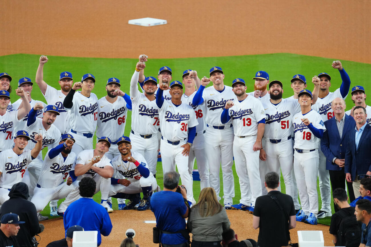 ドジャース対ダイヤモンドバックス　試合前、チャンピオンズリングセレモニーでリングを着け写真に納まるドジャースのロバーツ監督（中央）ら選手たち＝2026年3月27日（現地時間）