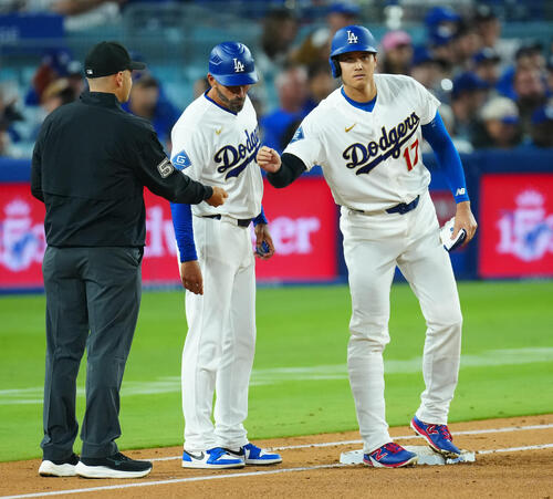 ドジャース対ダイヤモンドバックス 3回裏ドジャース1死、四球で出塁し一塁塁審からヒマワリの種をもらう大谷(右)(撮影・垰建太)