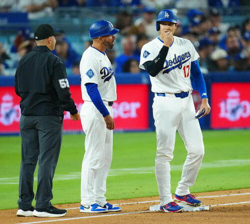 ドジャース対ダイヤモンドバックス 3回裏ドジャース1死、四球で出塁し一塁塁審からヒマワリの種をもらう大谷(右)(撮影・垰建太)