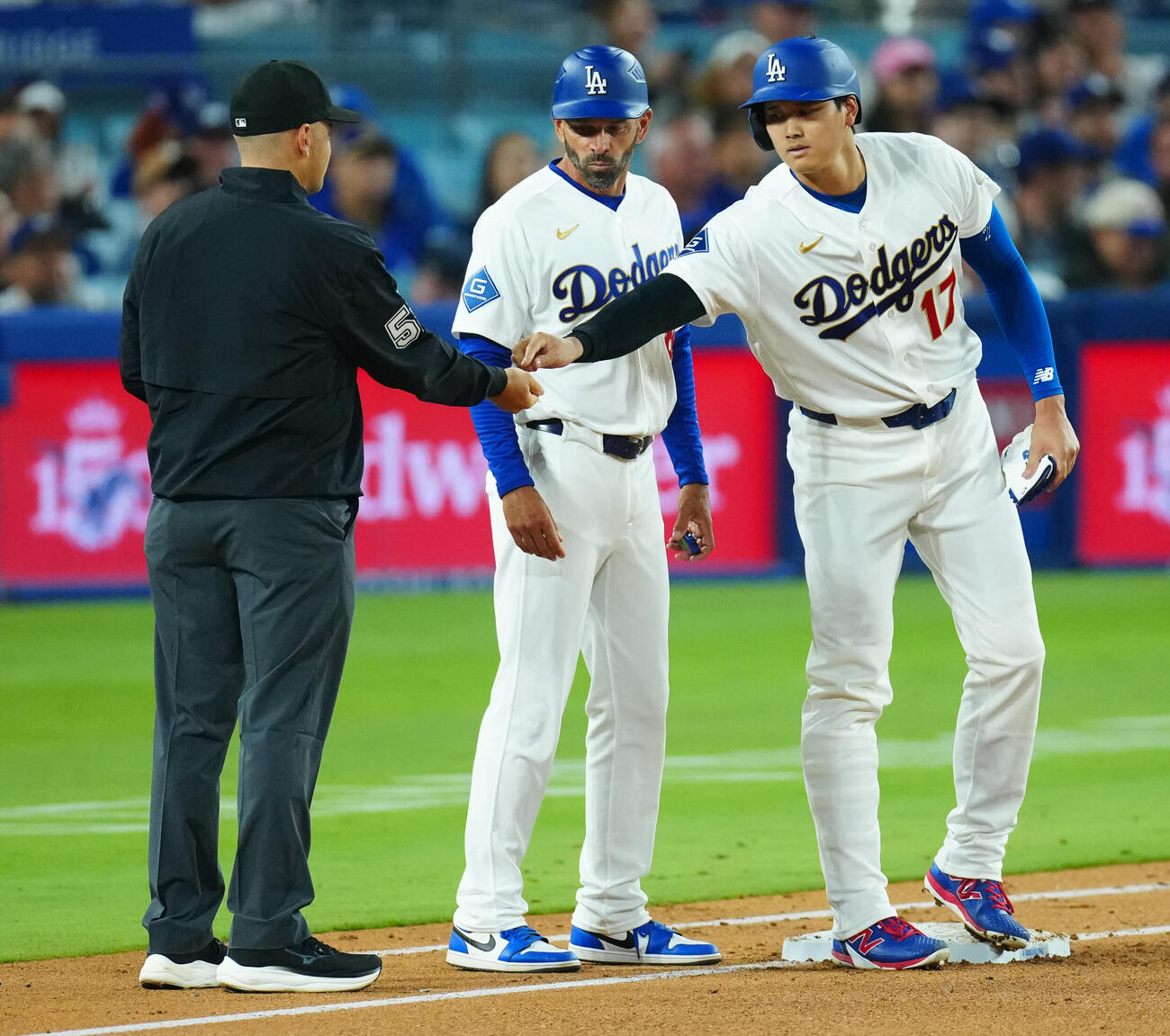 ドジャース対ダイヤモンドバックス　3回裏ドジャース1死、四球で出塁し一塁審からヒマワリの種をもらう大谷（右）（撮影・垰建太）